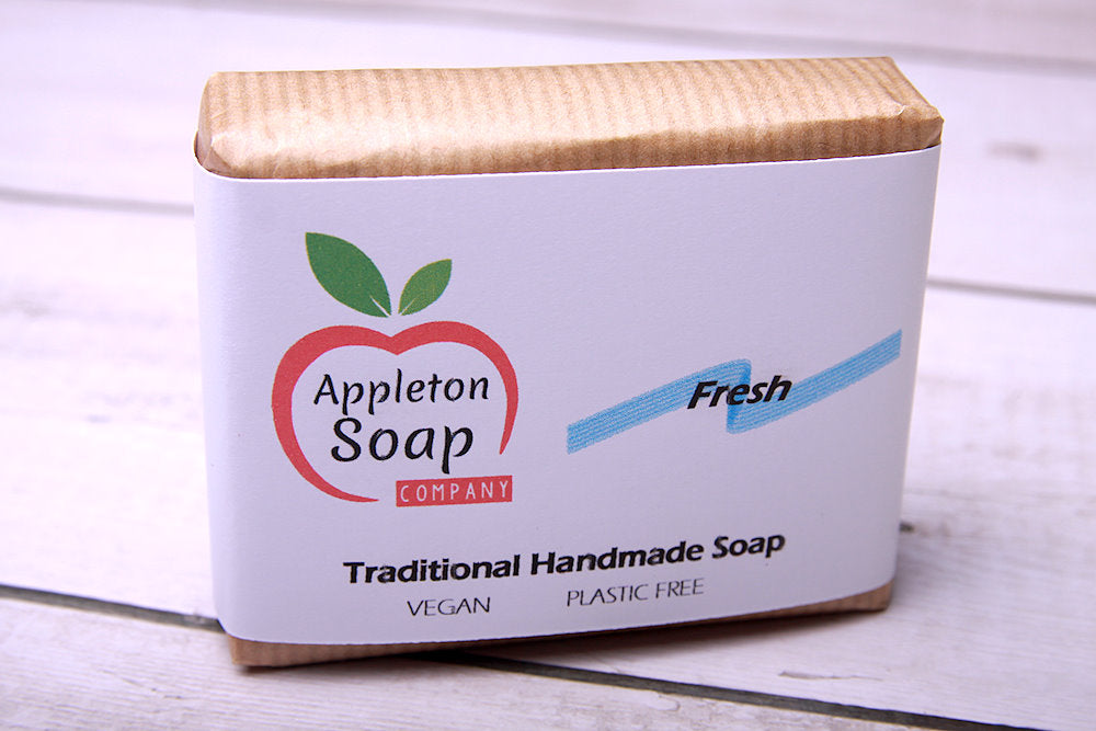 Fresh soap bar in brown paper wrapper with white banded label