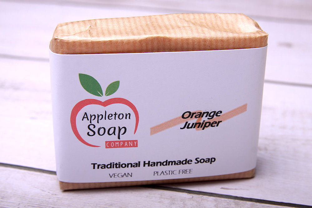 Orange juniper soap bar wrapped in brown paper with white banded label