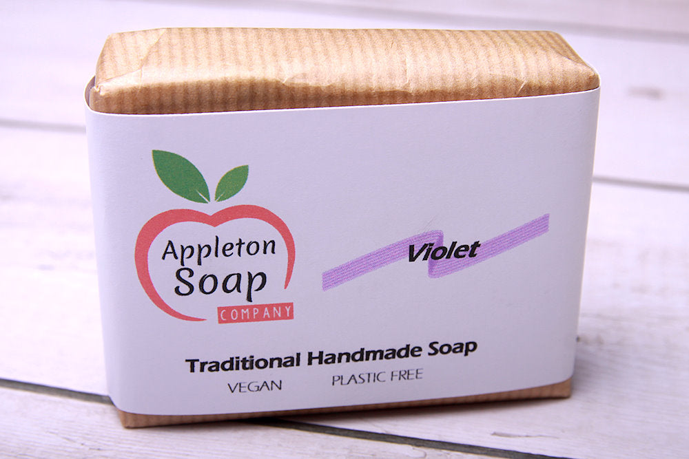Violet soap bar wrapped in brown paper with white banded label