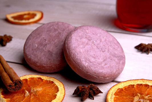Mulled Wine scented shampoo bar in pink shown with dried orange slices, star of anise, mulled wine and cinemon