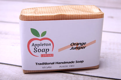 Orange juniper soap bar wrapped in brown paper with white banded label